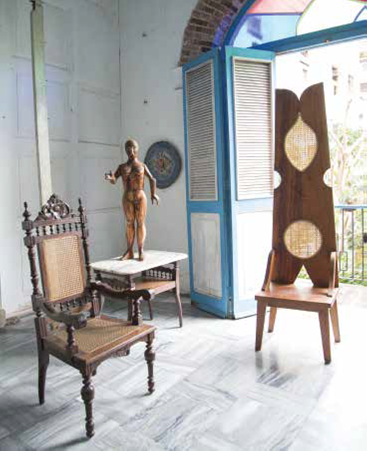 In Nelson Domínguez’s historic Old Havana studio, Victorian pieces are in dialogue with his clothespin-backed throne—behind is a balcony overlooking the extensive rear garden.