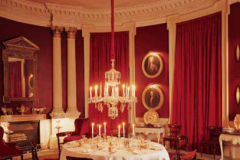 The dining room, converted from the original chapel; real candles burn in the chandelier. Under the starched white tablecloth is red damask that matches the painted walls and thick curtains.