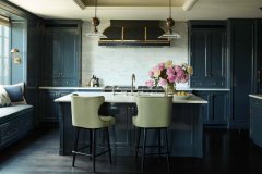 p. 22-23 The austere elegance of this kitchen—its simple, symmetrical architectural elements, careful alignment of marble countertops, and rich blue lacquerwork— is softened by the curvaceous profile of the barstools and inviting window seat. Photo Credit: Simon Upton