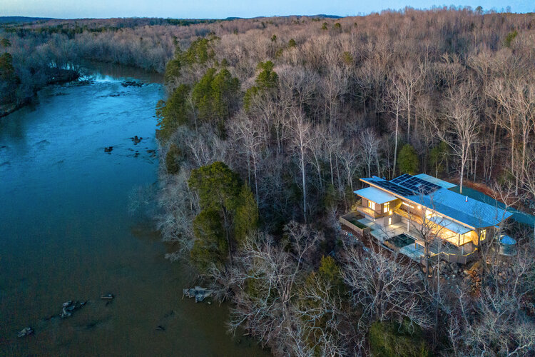 “Walking down by the riverbank, there were so many trees cantilevered and bent out over the Haw River, that I said: ‘I want this house to bend out over the river too,’” Schecter says.